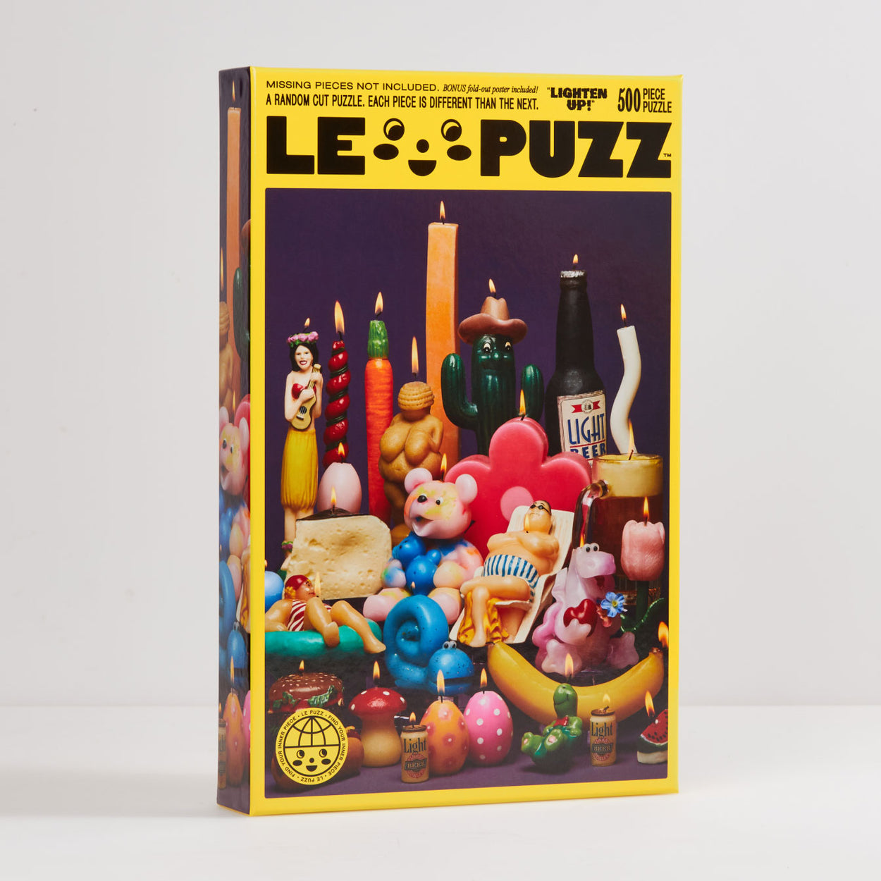 Lighten Up! Puzzle | Le Puzz | 500 Pieces: various bright color retro kitsch candles puzzle. Lighten Up is a special collection of rare and vintage novelty character candles. Featuring a very tall carrot, a long piece of cheese and a replica of one of the world's oldest sculptures.